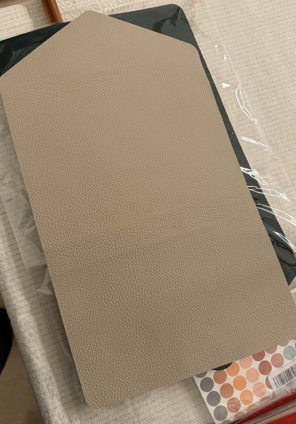Beige trifold exterior leather panel, laid flat before assembly