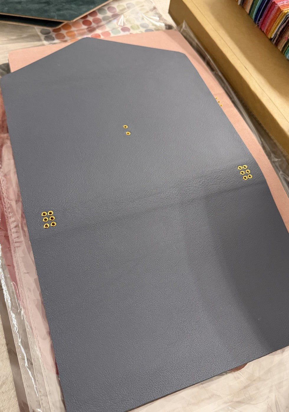 Gray trifold exterior leather panel, laid flat before assembly