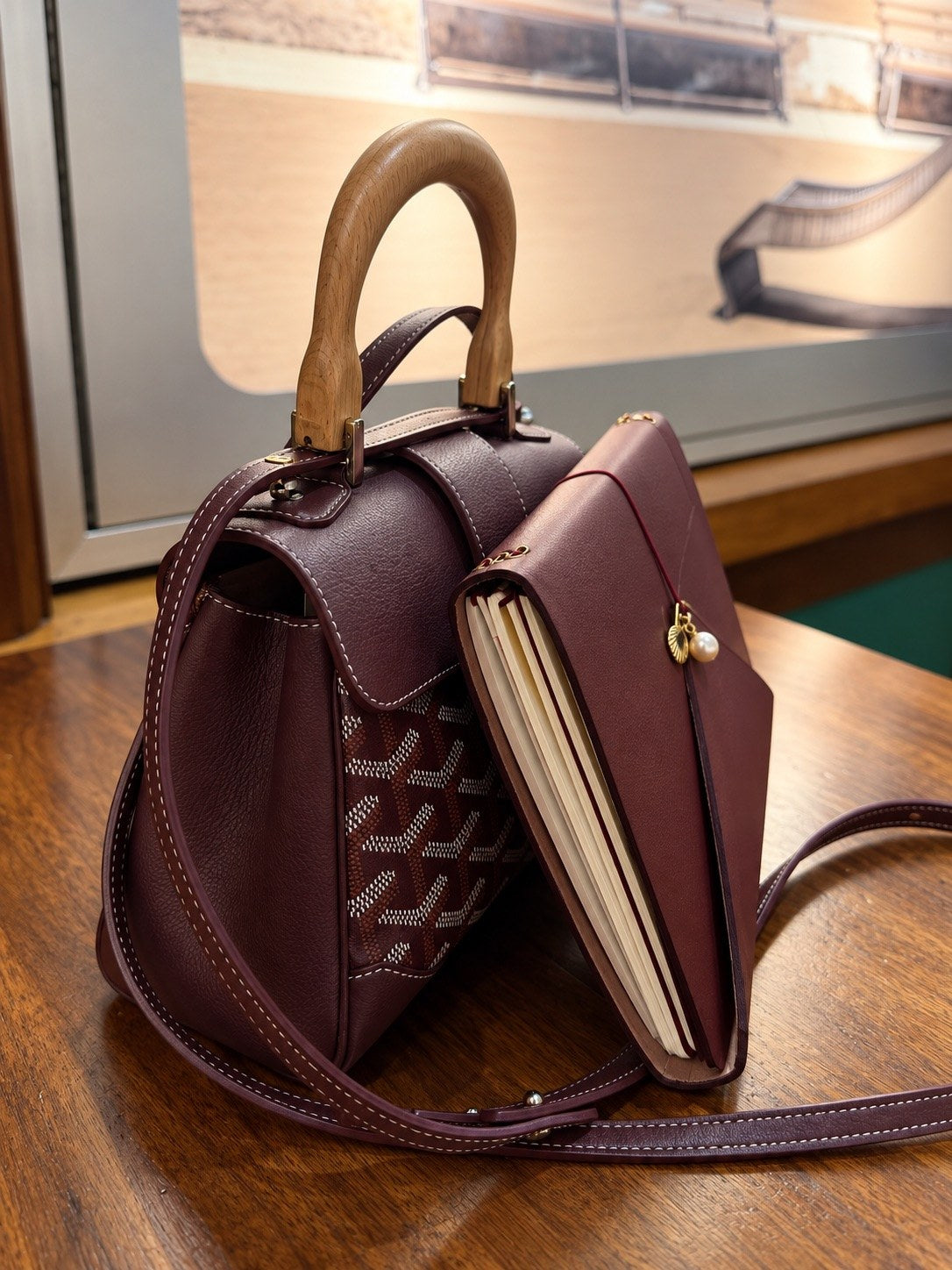 An Arrondi cover carried with a burgundy handbag